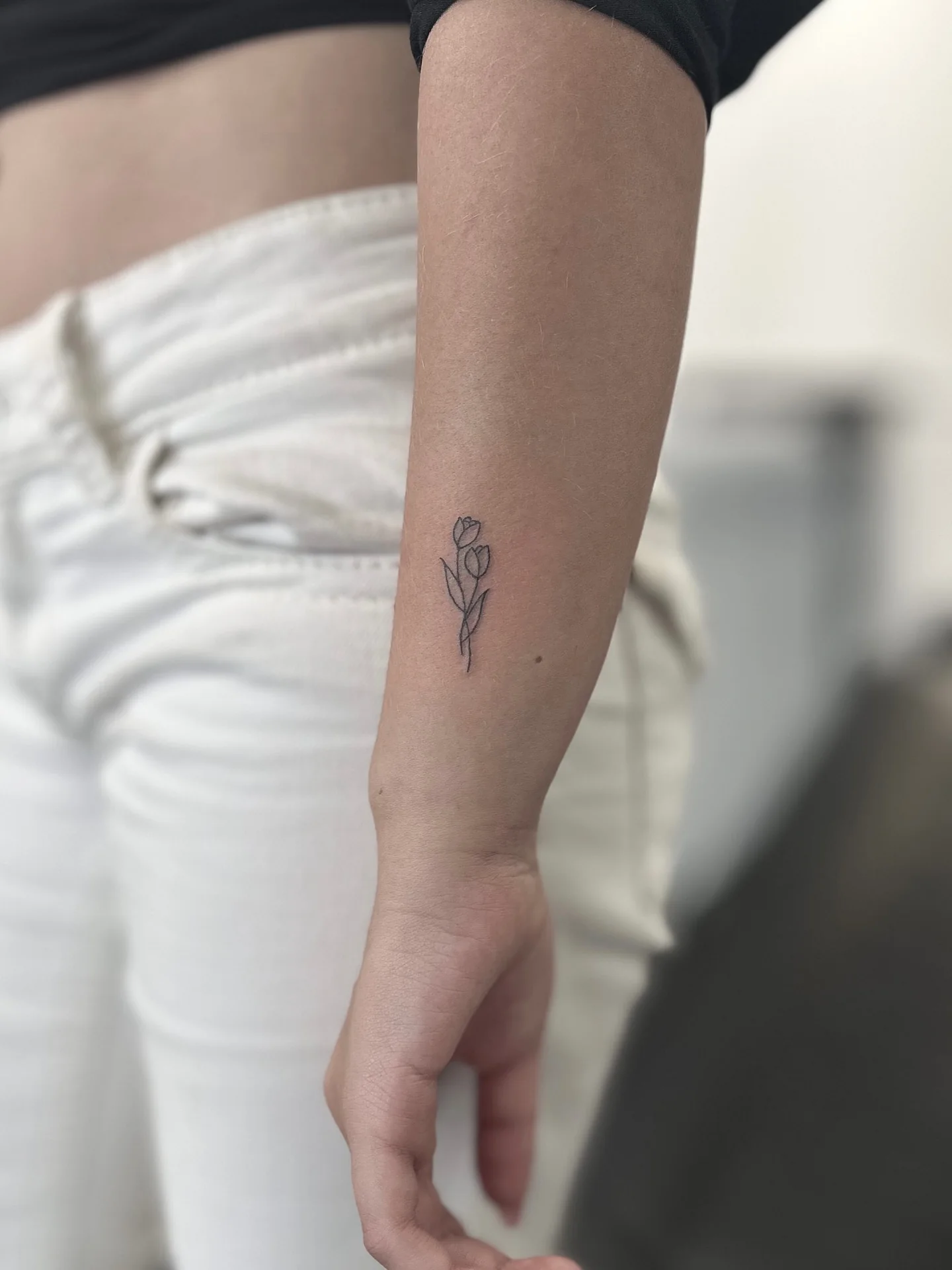Minimal tulpan tatuerad med tunna linjer