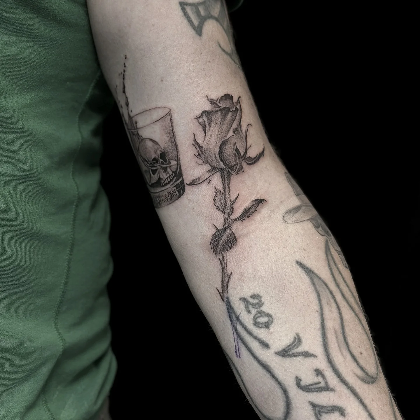 Svartgrå tatuering med ros och dödskalle